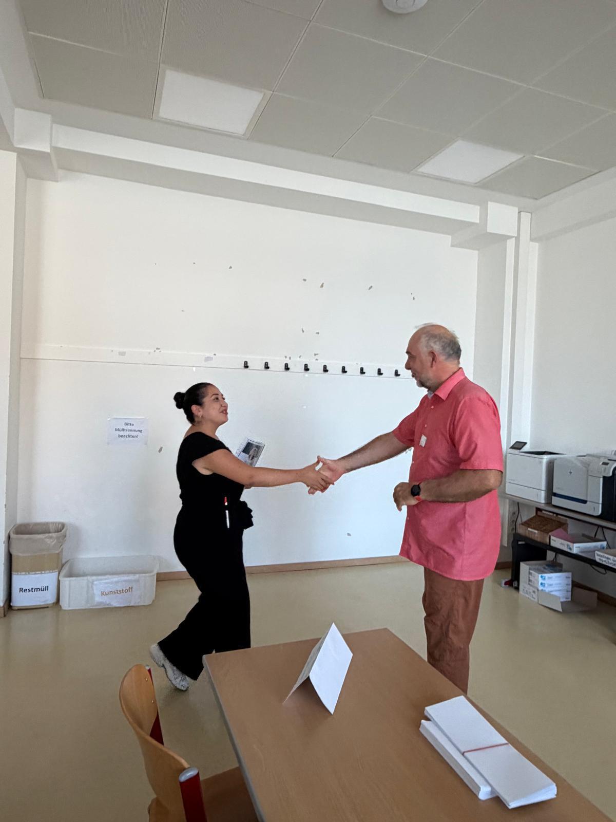 Workshop_AK_Bewerbung_8 Schüler:in spricht im Workshop mit einer/m Vortragenden über eine Bewerbungsmappe.